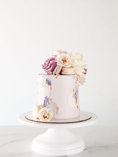 a white cake with pink and purple flowers on top