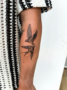 a woman's arm with a tattoo on it that has a bird flying over her shoulder