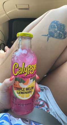 a woman holding a bottle of calypse in her lap