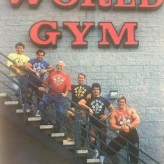 a group of men standing on top of a set of stairs in front of a gym