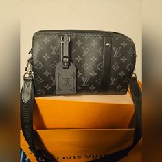 This Is The Louis Vuitton City Keepall Purchased From The Men's Section But It Can Definitely Be Unisex ! Please Review Pictures As They Best Showcase The Item. Also, Details And Specifications Or In A Picture Above . 100% Authentic Never Used It's Micro Chipped & I Have Proof Of Authenticity/Purchase Plus The Strap Is Authentic As Well. Since It Came With The City Keepall (For Those Of You Who Don't Know). Price Is Very Firm Please Do Not Comment On My Listing Talking About Trading Let's Keeps Designer Gray Shoulder Bag For Business, Gray Luxury Shoulder Bag For Evening, Luxury Gray Business Bags, Luxury Gray Evening Bag, Luxury Gray Shoulder Bag With Dust Bag, Designer Gray Bag With Branded Hardware, Luxury Gray Shoulder Bag, Luxury Black Monogram Canvas Shoulder Bag, Luxury Black Shoulder Bag With Gunmetal Hardware