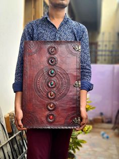 a man is holding up a large piece of art that looks like an intricate design