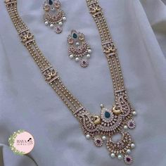 Embrace the timeless elegance of South Indian tradition with this stunning gold-plated haram necklace and earrings set. This exquisite piece features an intricate design adorned with sparkling CZ stones and delicate pearls, reminiscent of the grandeur of ancient temples. The long, layered necklace cascades down your chest, drawing attention to your neckline with its captivating beauty. Crafted with meticulous attention to detail, this set is perfect for: Bridal wear: Add an air of timeless sophistication to your wedding look with this breathtakingly beautiful set. Party wear: Make a statement at any special occasion with this eye-catching piece that is sure to turn heads. Cultural events: Immerse yourself in the rich heritage of South India with this authentic and elegant jewelry set. Feat Long Beads Haram, Rani Haram, Haram Diamond Necklace, Pearl Haram Designs Gold, Stone Long Haram Gold, Stone Haram Designs Gold, Bridal Necklace Designs, Indian Wedding Jewelry Sets, Diamond Jewelry Set