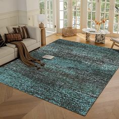 a living room filled with furniture and a large rug on top of a hard wood floor