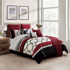 a bed with red and black comforters in a room