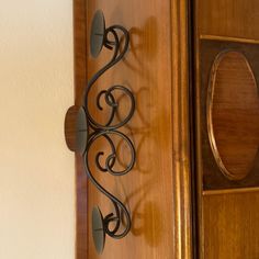 a wooden door with an iron scroll on the front and side panel, next to a mirror