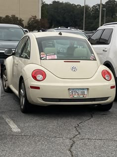 a white vw beetle parked in a parking lot