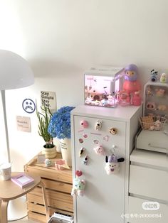 a refrigerator with many magnets on it next to a table and chair in a room