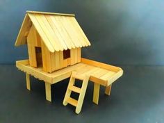 a wooden toy house sitting on top of a table next to a step stool and ladder