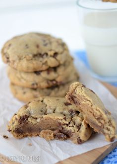 chocolate chip cookies are stacked on top of each other next to a glass of milk