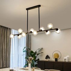 a dining room table and chairs with lights hanging from it's ceiling above them