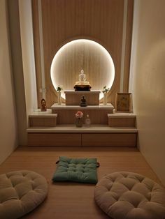 there is a meditation room with two stools and a buddha statue in the background