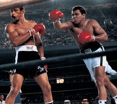 two men standing next to each other with boxing gloves on