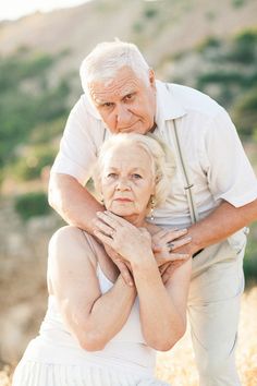 an older couple embracing each other in the grass