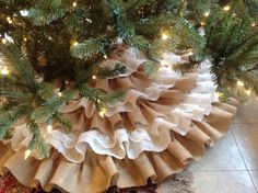 a christmas tree skirt is hanging from the top of a pine tree