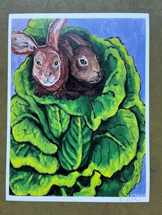 a painting of two rabbits sitting on top of a green leafy lettuce