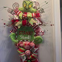 the grinch door hanger is decorated with red and green candy canes,