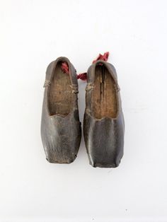 From our Heritage Collection This is a pair of antique hand cobbled leather shoes. The little shoes feature wood soles engraved 1884 on the left foot. Aged, black leather shapes the feet. A red ribbon accents the back of the right shoe. CONDITION In good condition with wear consistent with age and use. MEASUREMENTS Length: 6.5 inch .. 16.5 cm Width: 2.5 inch ... 6.4 cm Height: 2.25 inch... 5.7 cm 71306 1800s Shoes, Historical Shoes, Antique Clothing, Buy Shoes Online, Buy Shoes, Childrens Shoes, Red Ribbon, Vintage Shoes, Design Element