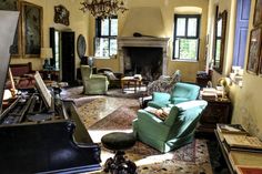 a living room filled with lots of furniture and a piano in the middle of it