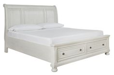 a white bed with two drawers on each side and a night stand underneath the headboard