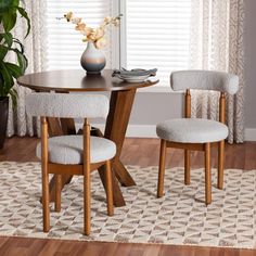 a dining room table with two chairs and a vase on top of it in front of a window