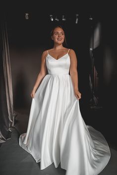 a woman in a white dress posing for the camera