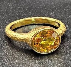 14k solid yellow gold hammered ring with 3.75 ct. 10x8 mm oval shape natural yellow sapphire, this item can also be ordered in white or rose gold with different color gemstones such as, amethyst, pink amethyst, green amethyst, blue topaz, London blue topaz, white topaz, citrine, garnet, smoky quartz, peridot, aquamarine, morganite & pink tourmaline, please contact me for a quote as each gemstone varies in price. I am a manufacturer of fine jewelry for over thirty years, loyalty and customer satisfaction have always been my ultimate goal. Please don't hesitate to contact me with any questions or ideas you may have. CUSTOM ORDERS ARE ALWAYS WELCOME. All my pieces come with a lifetime warranty. GOLD WEIGHT: 6.9 grams of solid 14k yellow gold. GEMSTONE INFO: 3.75 ct. 10x8 mm oval shape natural Fine Yellow Oval Sapphire Ring, Luxury Yellow Oval Sapphire Ring, Gold Oval Yellow Sapphire Ring, Oval Yellow Sapphire Ring In Gold, Formal Gold Ring With Yellow Sapphire, Formal Gold Sapphire Ring With Yellow Sapphire, Oval Yellow Sapphire Ring In Yellow Gold, Oval Yellow Sapphire Diamond Ring, Classic Oval Yellow Sapphire Ring