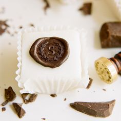 a waxed stamp sitting on top of a piece of paper next to some chocolate