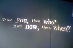 the words are projected on the wall in front of it's light fixture, which reads if not you, then who? if not now, then when?