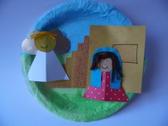 a paper plate with a child's drawing on it and a doll in the middle