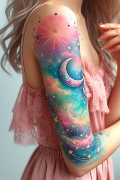 the girl is wearing a pink dress and holding her arm painted with stars, moon and crescent