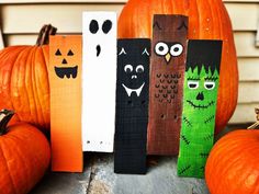 halloween decorations made out of wooden sticks and painted with black, orange and green colors