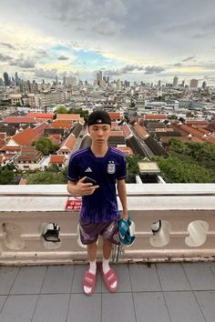 a young man standing on top of a building