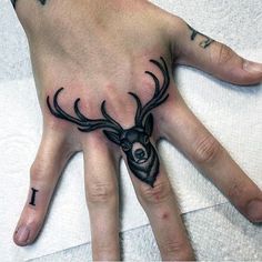 a person's hand with tattoos on it and two antlers painted on the palm