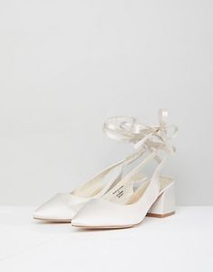 a pair of women's white shoes with bows