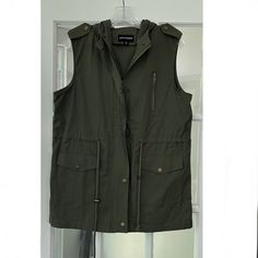 Nwot Zenana Outfitters Sleeveless Vest. Olive. Medium. Zip Front. Hooded. Cinch Waist. Approximate Measurements Length 29” Bust 20.5” Fabric 100% Cotton 2a Khaki Sleeveless Outerwear For Spring, Sleeveless Khaki Outerwear For Spring, Utility Sleeveless Vest For Winter, Utility Sleeveless Vest For Summer, Fall Utility Sleeveless Top, Sleeveless Utility Top For Fall, Fall Sleeveless Utility Top, Sleeveless Utility Vest For Winter, Utility Cotton Sleeveless Tops