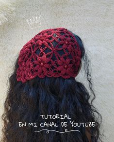 the back of a woman's head wearing a red crochet beanie