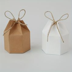 two small boxes tied with twine on each side, one is white and the other is brown