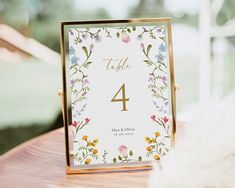 a table number with flowers and leaves on it