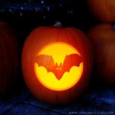 three carved pumpkins with bats on them