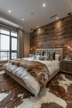 a large bed sitting next to a window in a room with wooden walls and flooring