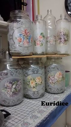 there are many glass jars with flowers on them