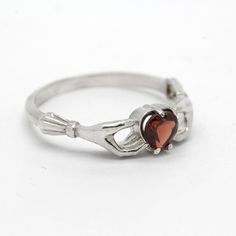 Claddagh Heart Genuine Garnet Sterling Silver Engagement Ring◆ The Claddagh ring has centuries of history, but today it symbolizes three things: friendship, loyalty and love. A beautiful small women ring with black heart zircon on the top. Two skeleton hands hold the black heart from different sides. Perfect fit for engagement or wedding in gothic style occasion. Simple design make it very comfortable and convenient for wearing everyday. We did blacked oxidation on the top and black zircons inse Symbolic Heart Shaped Rings As Gifts, Symbolic Heart-shaped Promise Ring, Gothic Rings For Valentine's Day Gift, Valentine's Day Gothic Rings As Gift, Gothic Heart-shaped Anniversary Jewelry, Formal Sterling Silver Heart Ring With Birthstone, Formal Heart Ring With Birthstone In Sterling Silver, Classic Sterling Silver Heart Ring With Birthstone, Classic Gemstone Heart Ring For Promise