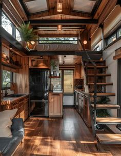 the interior of a tiny house with wood flooring and stairs leading up to the loft