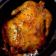 a close up of a chicken in a crock pot with some seasoning on it