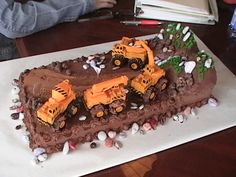 there is a chocolate cake with construction trucks on it