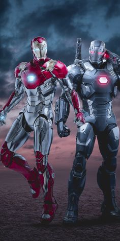 two iron man standing next to each other on a field with clouds in the background