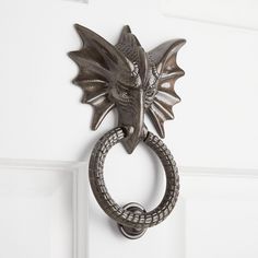 a door handle with a dragon head hanging on it's side and a snake ring in the middle