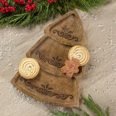 a christmas tree shaped serving platter with two slices of bread on it, surrounded by evergreen branches