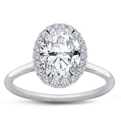 an oval cut diamond ring with halos on the shoulders